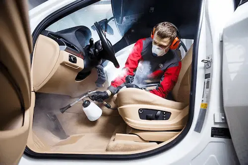 Specialista na čištění interiéru auta při práci v Praze